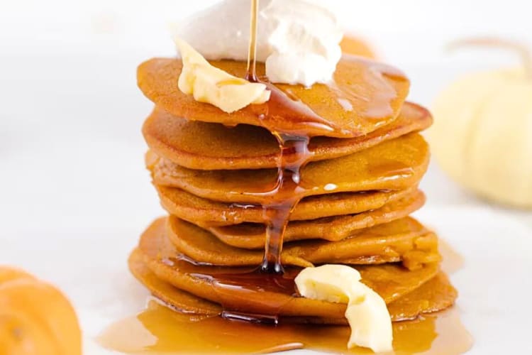 Stack of pumpkin pancakes topped with cream and syrup—perfect for a festive Thanksgiving brunch in Snoqualmie.